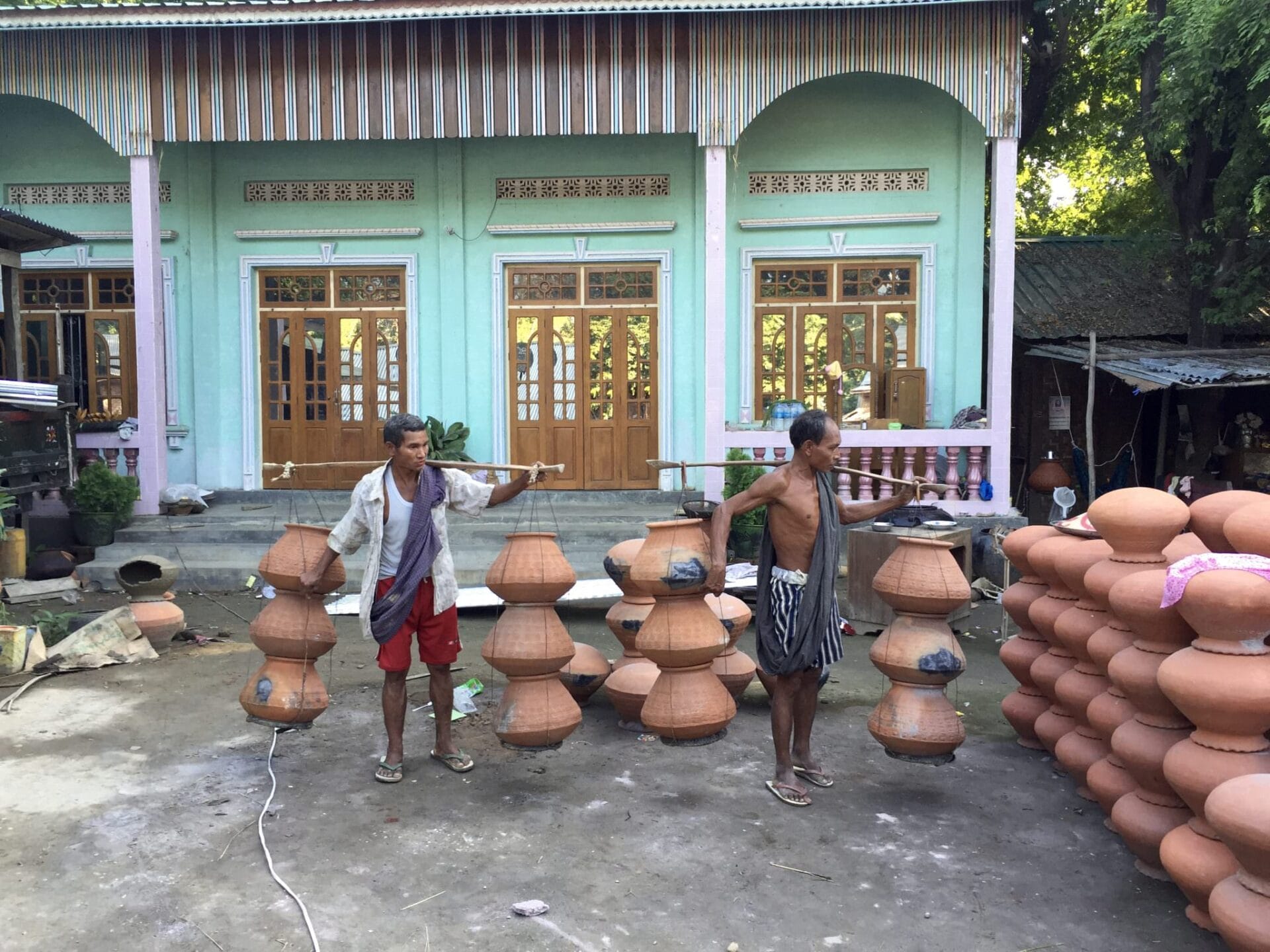 Men prepare to carry finished pots to the river bank. They will be loaded into boats of all shapes and sizes and sent all over the country. © 2015 Gail Jessen