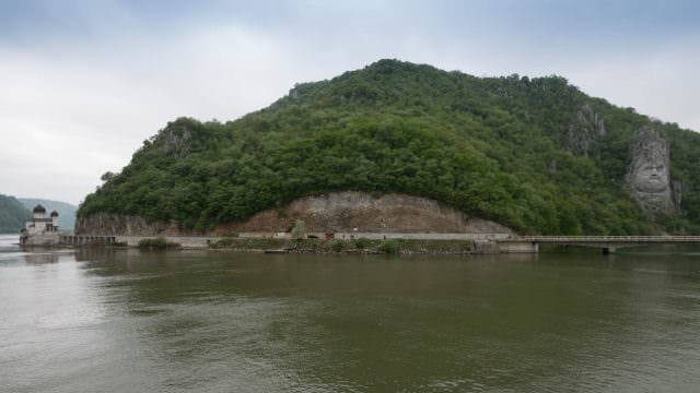 Rock sculpture of King Decebalus and an Orthodox church at the Iron Gates. © 2016 Ralph Grizzle